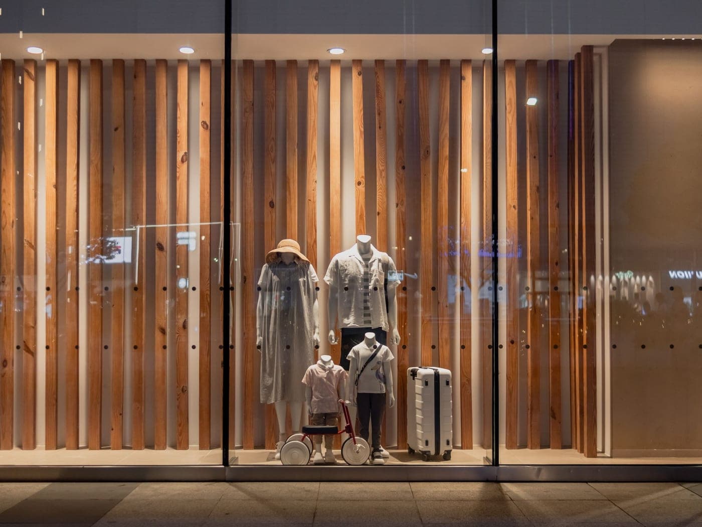 Vitrine nette d'une boutique, mannequins devant un panneau de bois vertical
